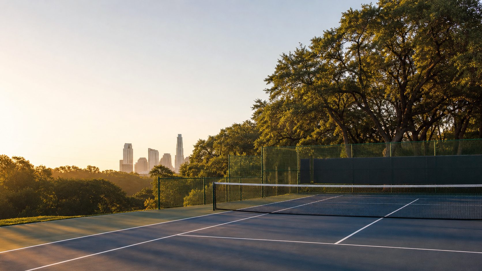 A public Austin tennis court with the skyline beyond the fence.